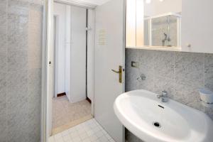 a white bathroom with a sink and a shower at Erikbeach Bilo in Bibione