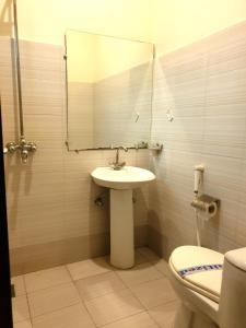 a bathroom with a sink and a mirror and a toilet at Shelton Hotel Johar Town Lahore in Lahore