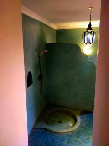 a bathroom with a toilet in the corner with a light at Riad Medina Taroudant in Taroudant +29 photos