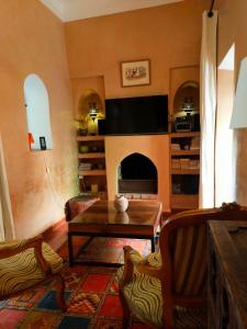 a living room with a table and a fireplace at Riad Medina Taroudant in Taroudant