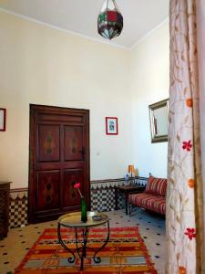 a living room with a table and a couch at Riad Medina Taroudant in Taroudant