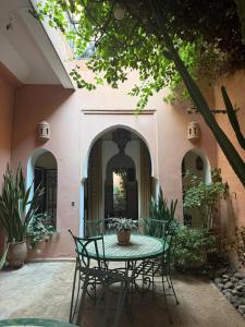 a patio with a table and chairs in front of a building at Riad Medina Taroudant in Taroudant