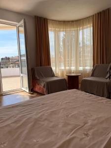 a hotel room with a bed and a large window at Hotel Andre in Burgas
