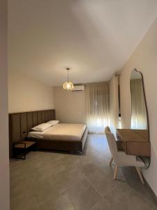 a bedroom with a bed and a desk and a chair at ORDAMS Villa in Himare +23 photos
