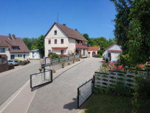 a street with a fence and a house with flowers at Ferienhaus Richard in Eschwege