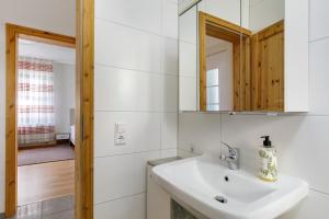 a white bathroom with a sink and a mirror at Ferienwohnung mit Parkmöglichkeit in Göppingen +95 photos