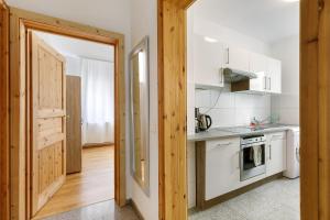 a kitchen with white appliances and a door leading to a hallway at Ferienwohnung mit Parkmöglichkeit in Göppingen