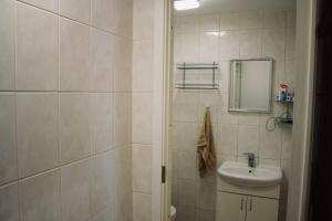a white bathroom with a sink and a mirror at Skyview Hostel in Tallinn