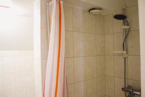 a shower with an orange shower curtain in a bathroom at Skyview Hostel in Tallinn