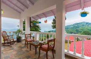 a porch with chairs and a view of the mountains at The Boho Mukteshwar in Mukteshwar