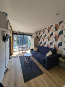 a living room with a blue couch and a table at Guest House in Gévezé