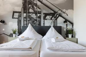 two beds with white sheets and pillows in a room at Hotel Restaurant Litermont in Nalbach +135 photos