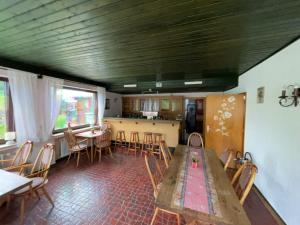 a dining room with a large wooden table and chairs at Hotel Haus Erlen in Olsberg