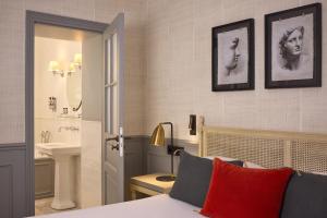 a bedroom with a bed and a bathroom with a sink at Charles V in Paris +108 photos