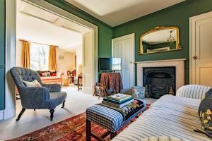 a room with a bed and a chair and a fireplace at Grand Georgian Residence in Bath