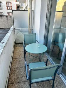 two chairs and a table on a balcony at Appartement carmes in Aurillac