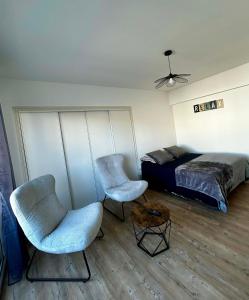 a bedroom with two chairs and a bed at Appartement carmes in Aurillac