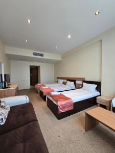 a room with four beds and a couch at Gabala Tufandag City Hotel in Gabala +67 photos