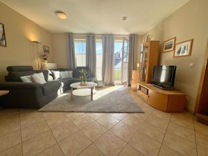 a living room with a couch and a tv at Altes Wasserwerk App 22 in Wustrow