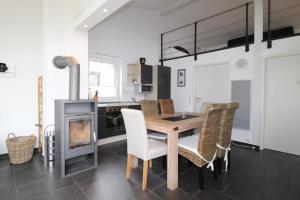 a kitchen with a table and chairs and a fireplace at Ferienhaus LUV in Wustrow