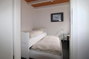 a white room with a bed and a mirror at Ferienhaus LUV in Wustrow