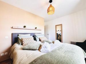 a bedroom with a large bed with pillows at L'Orée des Pins - Suite parentale - Merlimont in Merlimont
