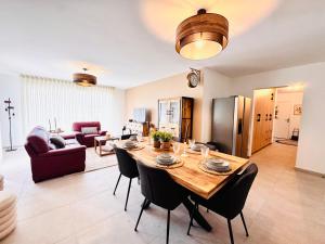 a dining room and living room with a table and chairs at L'Orée des Pins - Suite parentale - Merlimont in Merlimont
