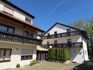 ein großes weißes Gebäude mit einem Balkon auf dem Dach in der Unterkunft Hotel am Buchwald in Esslingen