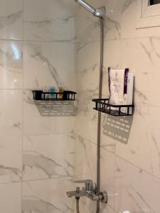 a bathroom with a shower with white marble walls at منازل الجود , أبحر - Manazil Al Joud , Obhour in Jeddah +12 photos
