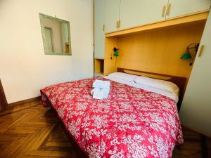 a bedroom with a red bed with towels on it at Suite Semeria 44 - Sanremo in Sanremo
