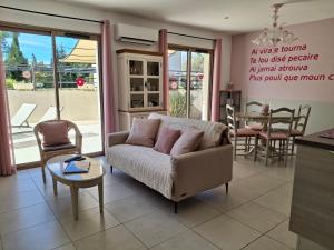 a living room with a couch and a table at Le Cabanon de Laura in L'Isle-sur-la-Sorgue