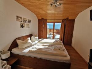 a bedroom with a bed in a room with a window at Hotel Karwendelblick in Urfeld