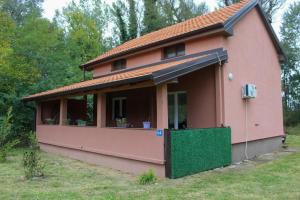 a small pink house with a green door at Vikendica Drinska Flora, Loznica - Lipnički Šor in Lipnički Šor