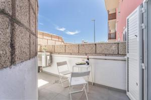a small balcony with two chairs and a table at Olivia’s Beach in Candelaria