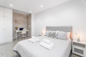 a white bedroom with a large white bed and a desk at Olivia’s Beach in Candelaria +18 photos