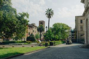 a street in a city with palm trees and buildings at Dimora il Respiro di Pisa in Pisa