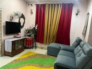 a living room with a couch and a television at Tokma homestay in Kuala Terengganu