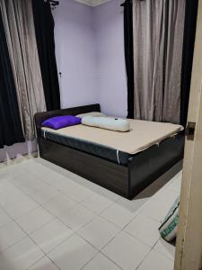 a bed with two pillows on it in a room at Tokma homestay in Kuala Terengganu