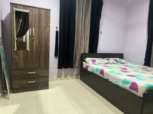 a bedroom with a bed and a dresser and a mirror at Tokma homestay in Kuala Terengganu