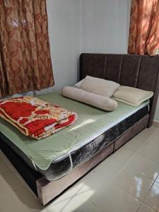 a bed sitting in a room with avertisementatronatronstrationstrationstration at Tokma homestay in Kuala Terengganu +1 photo