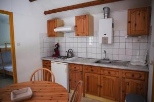 a kitchen with wooden cabinets and a table and a sink at Camping Terre d'Armor in Bourseul