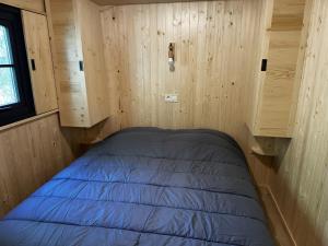 a small bed in a room with wooden walls at L'arbousier in Clermont-lʼHérault +28 photos