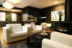 a living room with white furniture and a fireplace at Hakuba Echo Hotel and Apartments in Hakuba