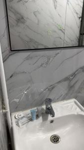 a bathroom sink with a mirror above it and a sink at Саратан отель in Osh +14 photos