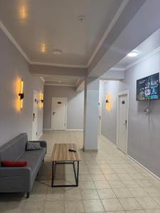 a living room with a couch and a coffee table at Саратан отель in Osh