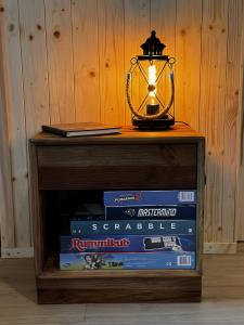 a table with books and a lamp on top at L'arbousier in Clermont-lʼHérault