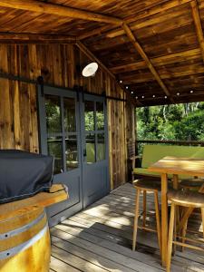 a wooden deck with a table and chairs and a door at L'arbousier in Clermont-lʼHérault