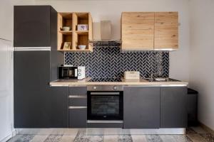 a kitchen with gray cabinets and a counter top at Maison l’Oustaou Cornillonnais in Cornillon-Confoux