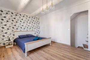 a bedroom with a bed in a room with a wall at Maison l’Oustaou Cornillonnais in Cornillon-Confoux