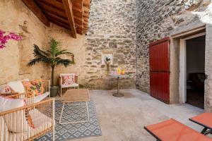 a patio with a red door and a table and chairs at Maison l’Oustaou Cornillonnais in Cornillon-Confoux
